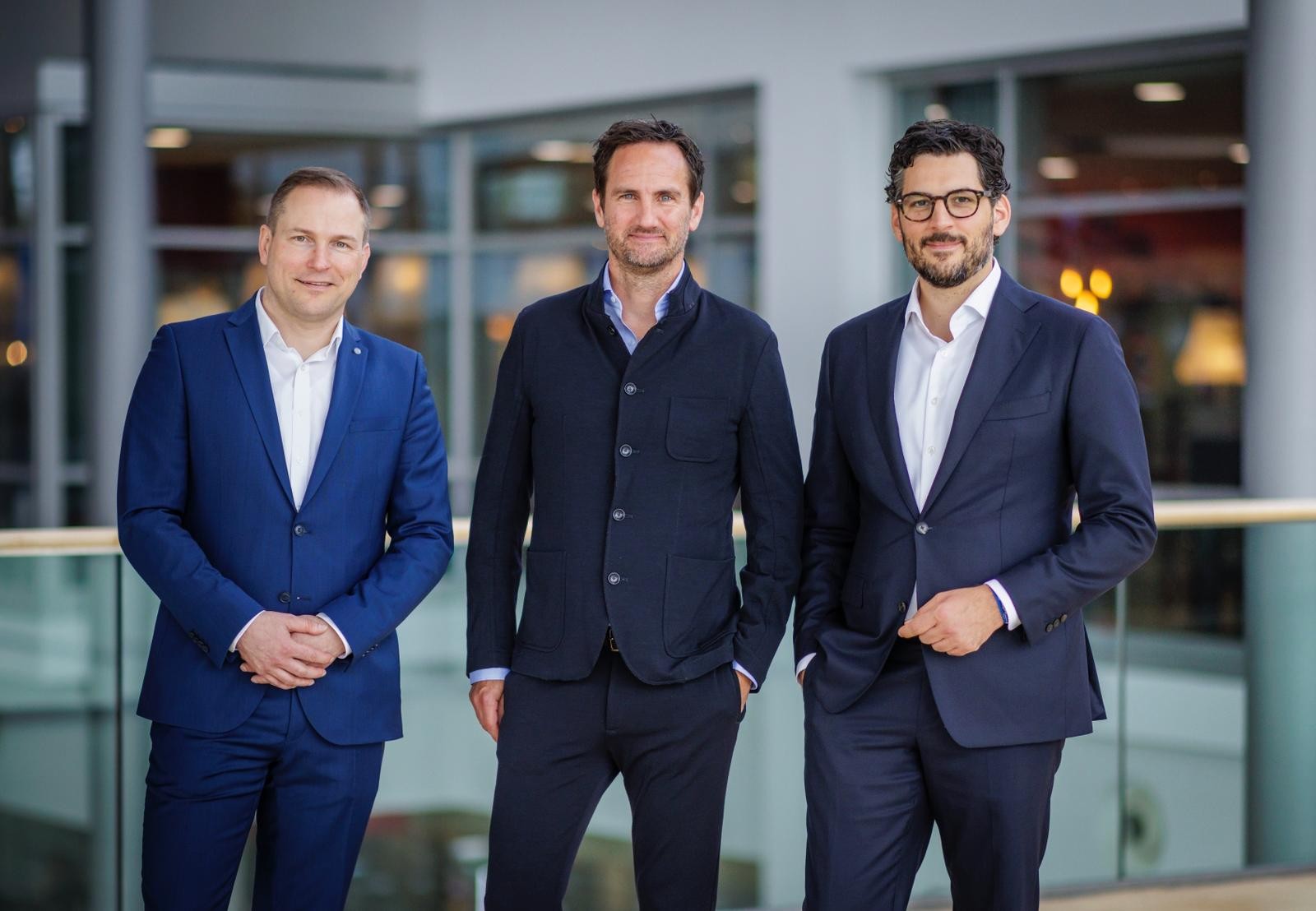 Drei Mitglieder der Geschäftsführung der redi-Group stehen gemeinsam in einem modernen Unternehmensumfeld.