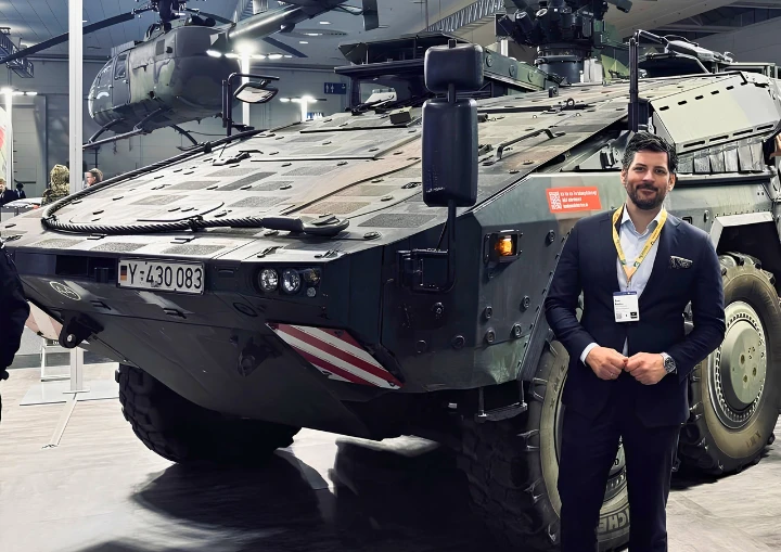 Onur Kayhan, Geschäftsführer Vertrieb und Marketing der redi-Group, vor einem gepanzerten Militärfahrzeug.